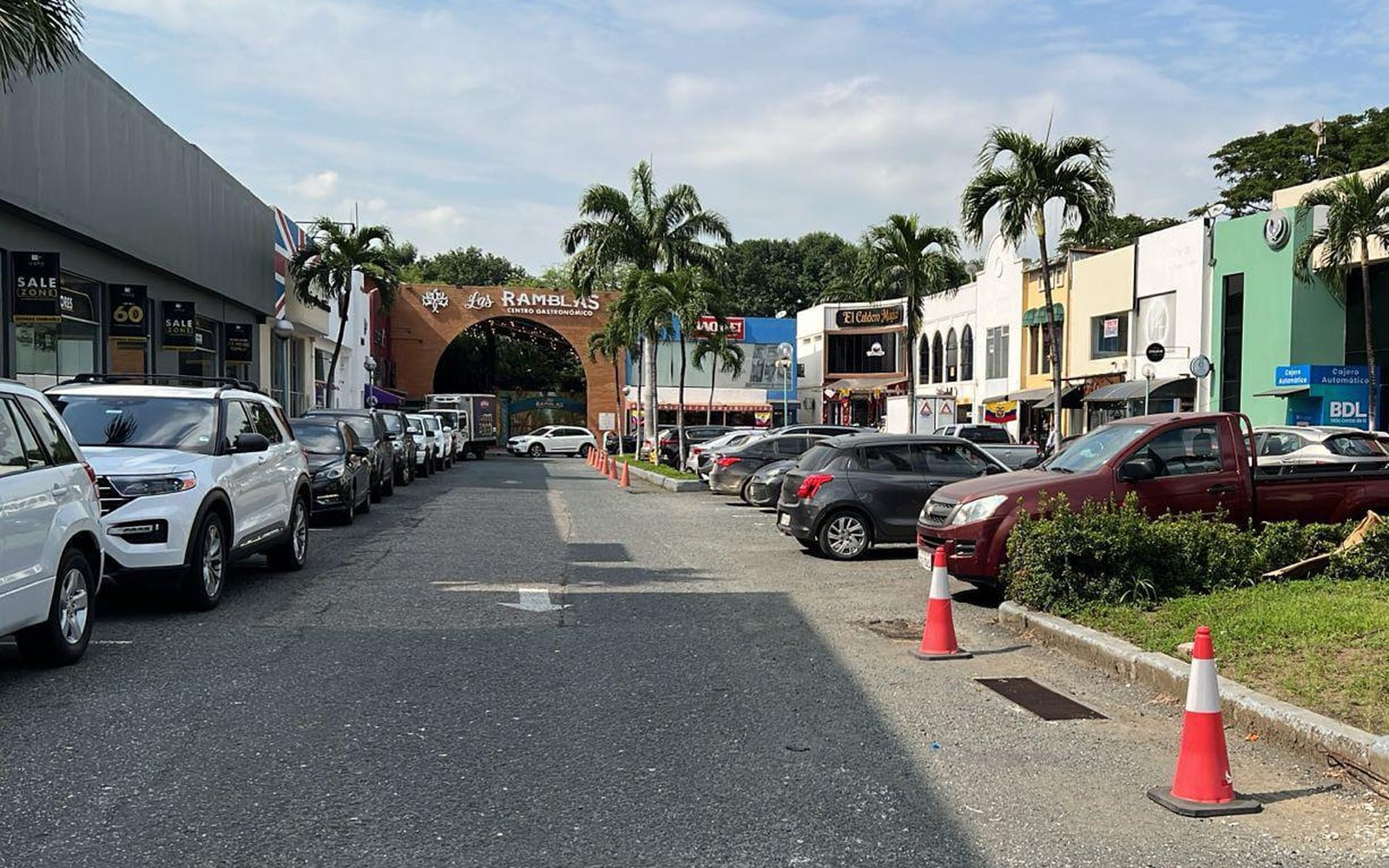 Parqueadero del C.C. Aventura Plaza con automóviles estacionados a ambos lados