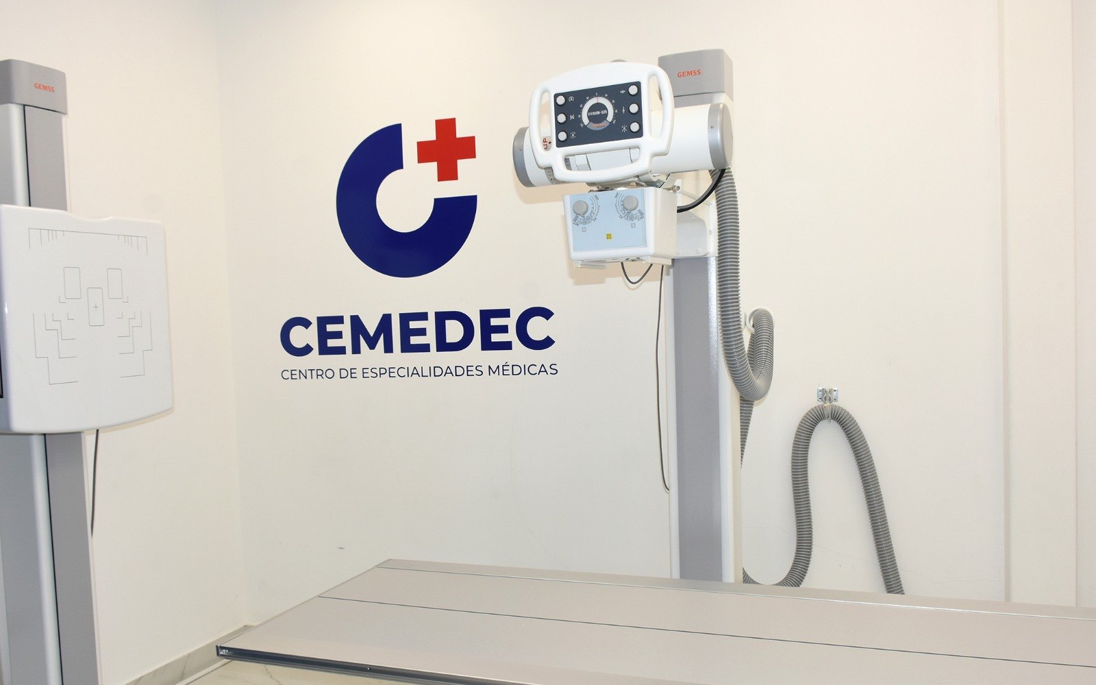 Sala de rayos X digital de CEMEDEC con equipo GEMSS y el logotipo del centro en la pared
